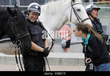 Vancouver, Kanada. 3. Oktober 2014. Ein Bewohner nimmt einen genaueren Blick auf ein Pferd neben einem Vancouver berittene Polizei Jack Poole Plaza in der Innenstadt von Vancouver, Canada, 3. Oktober 2014. Gehostet von Vancouver Police Department, das 11. jährliche Polizei montiert Einheit Seminar startete am Freitag. Während der sieben-Tage-Seminar wird insgesamt 17 berittene Einheiten aus Kanada, USA und Australien für Schulung und Austausch von polizeilichen Fähigkeiten auf Fahrt gemeinsam. © Liang Sen/Xinhua/Alamy Live-Nachrichten Stockfoto