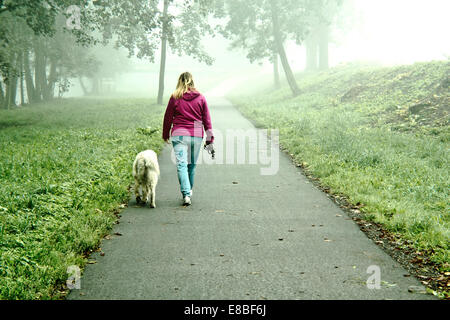 Frau zu Fuß mit ihrem Hund in der Natur Stockfoto