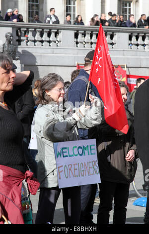 Eine Frau hält ein Schild mit der Aufschrift "Welcome Ausländer" während einer Kundgebung auf dem Londoner Trafalgar Square, Mark UN-Antirassismus-Tag 2014 Stockfoto