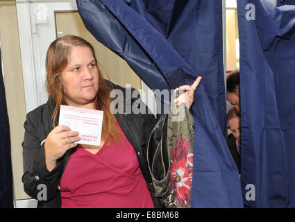 Riga, Lettland. 4. Oktober 2014. Eine Frau bereitet sich auf ihre Stimme in einem Wahllokal in den Vorstädten von Riga, Lettland, 4. Oktober 2014 abzugeben. Umfragen eröffnet in Lettland bei den allgemeinen Wahlen am Samstagmorgen mit 13 politische Parteien und Wahlen Blöcke im Wettbewerb um die 100 Sitze in die Saeima, das lettische Parlament. Bildnachweis: Guo Qun/Xinhua/Alamy Live-Nachrichten Stockfoto