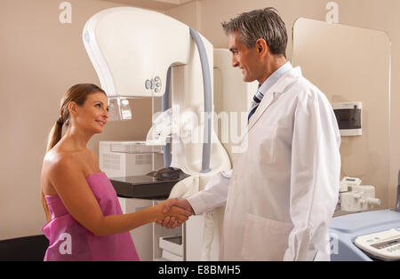 Männlichen Arzt und Patientin Händeschütteln im Krankenzimmer. Stockfoto