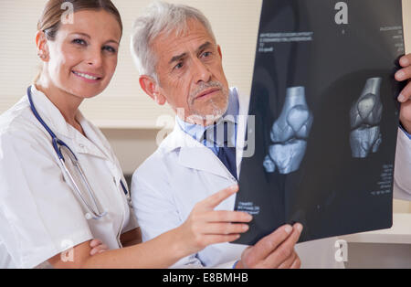 Reifen männlichen Arzt und junge Assistentin Analyse Patient x-ray Test. Stockfoto
