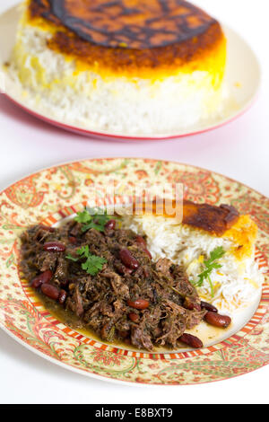 Iranische (persische) Kraut und Lamm Koresh mit persischer Safranreis serviert. Das Fleisch ist mit Massen von Kräutern langsam geschmort. Stockfoto