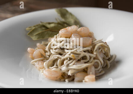 Gula oder Surimi, Gericht zubereitet mit Knoblauch und Olivenöl, sautierten Garnelen. Spanische gastronomischen Genuss, dunklem Holz. Hor Stockfoto