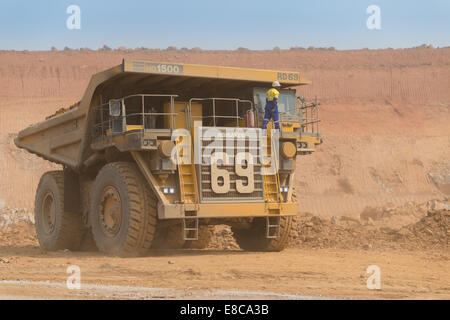 Der Luftfahrtunternehmer klettert bis zu der Kabine von seiner großen Komatsu Muldenkipper in einem afrikanischen Tagebau Kupfer mine. Stockfoto