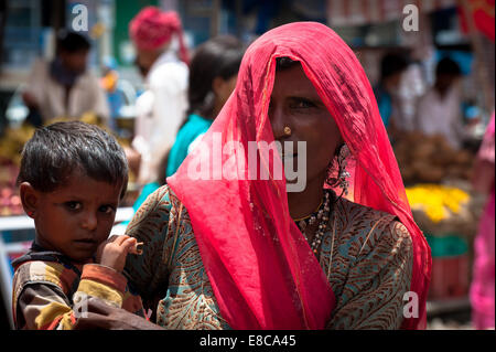 Landleben in Rajasthan, farbige Frau in traditioneller Kleidung mit ihrem kleinen Kind Stockfoto