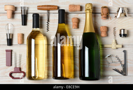 Hohen Winkel Schuss Wein und Champagner Flaschen umgeben von Accessoires wie Korkenzieher, Stopper, Ausgießer und Korken. Horizont Stockfoto