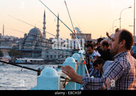 ISTANBUL, Türkei - 27. September 2012: Eine Gruppe von Männern Fisch auf der Galata-Brücke während des Sonnenuntergangs. Stockfoto