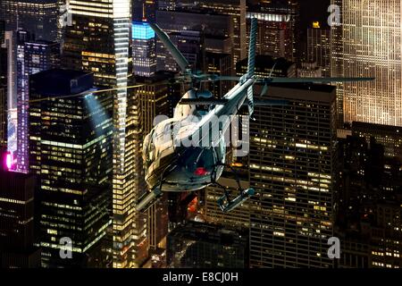 Helikopter Nachtflug zwischen den Wolkenkratzern von New York in Manhattan Stockfoto