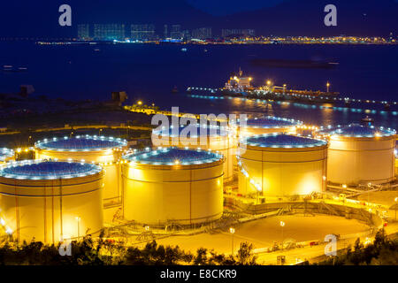 Große industrielle Öltanks in einer Raffinerie in der Nacht Stockfoto