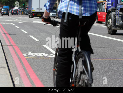 Ein Radfahrer nähert sich ein Radweg in eine Busspur am Westminster Bridge in London, England Stockfoto