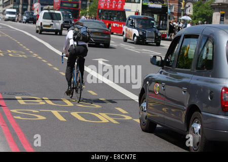 Ein Taxi zu überholen ein Radsportler, die auf einer Busspur in London, England Stockfoto