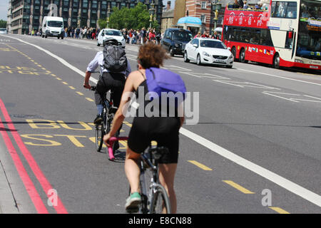 Zwei Radfahrer, Verkehr und einem Tour-Bus Reisen in Westminster Bridge in London, England Stockfoto