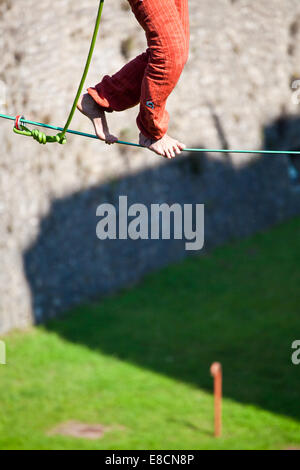 Slacklinen ist eine Praxis in Balance, die in der Regel aus Nylon oder Polyester Gurtband Spannung zwischen zwei Ankerpunkten verwendet. Stockfoto