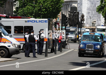 Metropolitan Police und ihre Fahrzeuge, die Teilnahme an einer Demonstration in Whitehall, London. Ein Taxi übergibt. Stockfoto