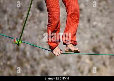 Slacklinen ist eine Praxis in Balance, die in der Regel aus Nylon oder Polyester Gurtband Spannung zwischen zwei Ankerpunkten verwendet. Stockfoto