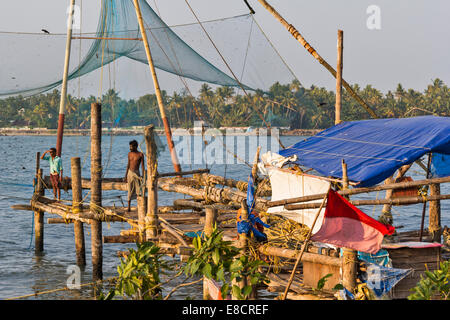 CHINESISCHE NETZE AM HAFEN KOCHI ODER COCHIN INDIEN MIT ZWEI FISCHER Stockfoto