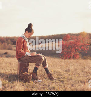 Hipster Mädchen zeichnen im Herbst im freien Stockfoto