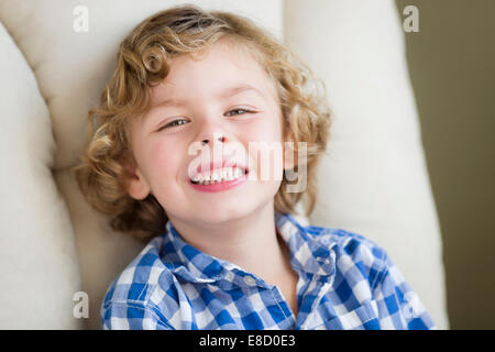 Süße Blonde junge Lächeln für Porträt im Stuhl sitzen. Stockfoto