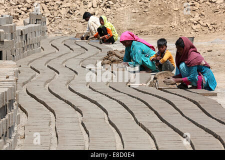 weibliche Ziegelei Arbeiter Form Ziegel auf ein Feld der Patoki Ziegelei in der Nähe von Lahore, Pakistan Stockfoto