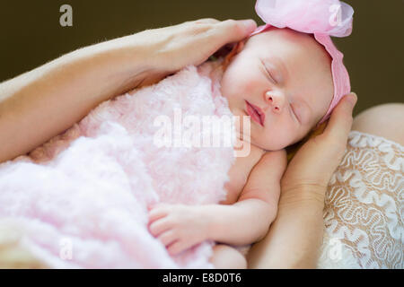 Sanfte Hände der Mutter hält ihr kostbares neugeborenes Baby Girl. Stockfoto