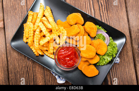 Teil des golden Chicken Nuggets mit Pommes-frites Stockfoto