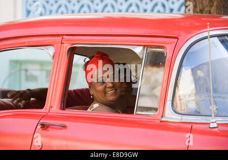 Frau, die aus einem Autofenster, Oldtimer, Havanna, Kuba Stockfoto