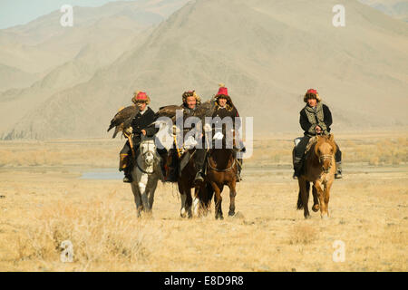 Vier kasachischen Adler Jäger auf ihren Pferden auf dem Weg zum Eagle Festival in Sagsai, Bayan-Oelgii-Aimag, Mongolei Stockfoto