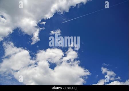 Jet mit Kondensstreifen am bewölkten Himmel, Deutschland Stockfoto