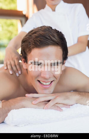 Gut aussehender Mann Erhalt Schultermassage im Wellnesscenter Stockfoto