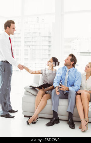 Geschäftsmann Händeschütteln mit Frau neben Menschen warten interview Stockfoto