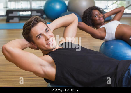 Paar macht Sit Ups auf Gymnastikbälle Stockfoto
