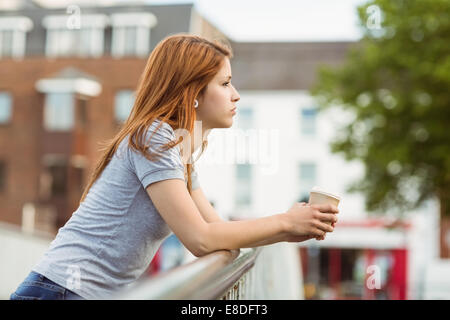 Frau mit Kaffee Tasse Tagträumen auf der Brücke Stockfoto