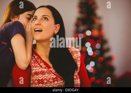 Tochter erzählt ihrer Mutter ein Geheimnis von Weihnachten Stockfoto