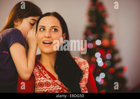 Tochter erzählt ihrer Mutter ein Geheimnis von Weihnachten Stockfoto