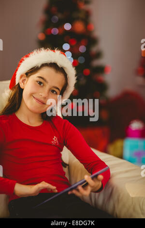 Festliche Mädchen mit TabletPC auf couch Stockfoto