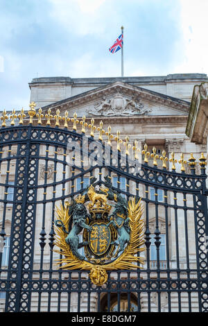 Detail des Buckingham Palace Tore mit Queen es Kamm und britische Flagge auf der Palast-Fassade in London, Großbritannien Stockfoto