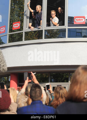 Magdeburg, Deutschland. 5. Oktober 2014. Musiker Georg Listing (L-R), Bill Kaulitz, Gustav Schaefer und Tom Kaulitz von der Band "Tokio Hotel" Welle ihre Fans nach einem hörenden Konzert beim Radiosender in Magdeburg, Deutschland, 5. Oktober 2014 sah. Foto: Jens Wolf/Dpa/Alamy Live News Stockfoto