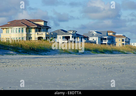 Eine Reihe von direkt am Meer, gehobene, Strandhäuser. Kurz vor Sonnenuntergang mit schönen Licht und Himmel genommen. Stockfoto