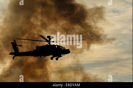 APACHE-KAMPFHUBSCHRAUBER MIT WOLKE AUS RAUCH LANDSCHAFT Stockfoto