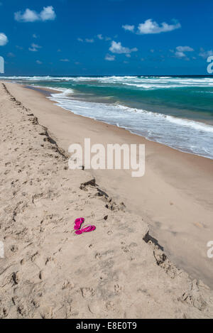 Rosa Flip Flops an einem einsamen Strand auf Barbados. Stockfoto