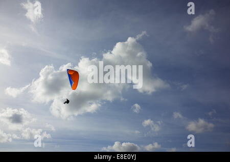 Hängegleiter im bewölkten blauen sonnigen Himmel. Stockfoto