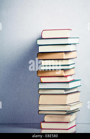 Sehr hohe Stapel Bücher auf dem Tisch Stockfoto