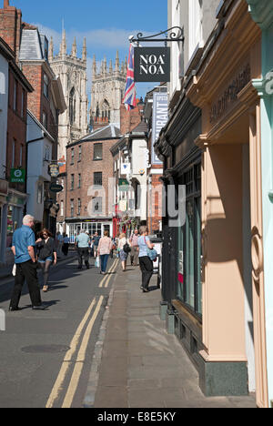 Geschäfte Geschäfte in Low Petergate mit dem Münster im Hintergrund im Sommer York city Town Center North Yorkshire England UK Vereinigtes Königreich GB Großbritannien Stockfoto