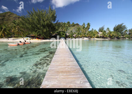 kleine Boote vor Anker in der Nähe von einem Pier in einer tropischen Lagune in der Nähe von einem weißen Sandstrand Stockfoto