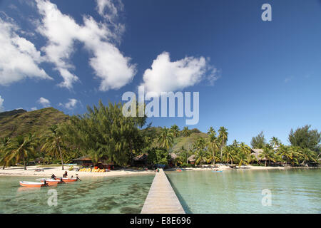 kleine Boote vor Anker in der Nähe von einem Pier in einer tropischen Lagune in der Nähe von einem weißen Sandstrand Stockfoto