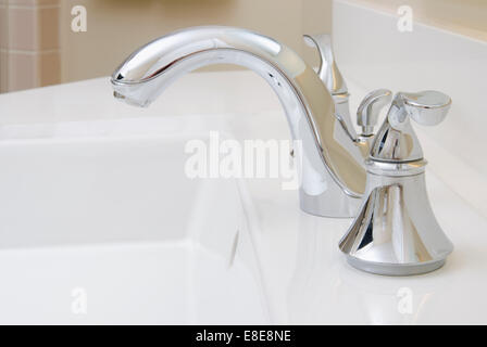 Waschbecken im Badezimmer und Zähler: Nahaufnahme eines Badezimmer Waschbecken, Chromhahn und weiße Theke. Stockfoto