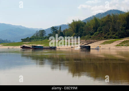 Horizontale Ansicht des traditionellen Longboat Passagierfähren vertäut entlang des Mekong-Flusses in der trockenen Jahreszeit. Stockfoto