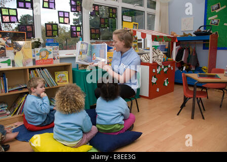 Liest eine Geschichte 3 Baumschule Schüler Lehrer Stockfoto