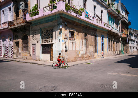 Ein junge kubanische sein Fahrrad unter heruntergekommen Gebäude im zentralen Teil von Havanna Kuba Stockfoto